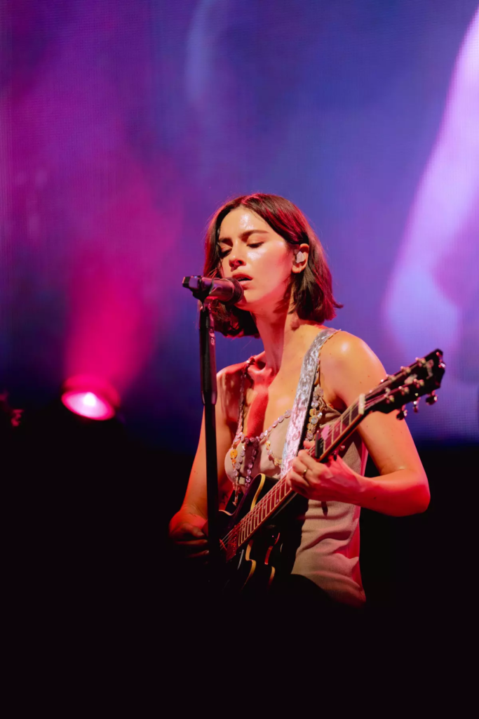 Gracie Abrams singing and playing the guitar