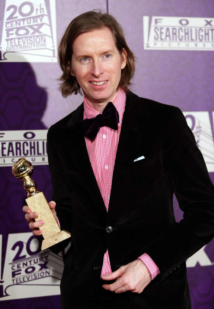 Wes Anderson holding his Golden Globe award
