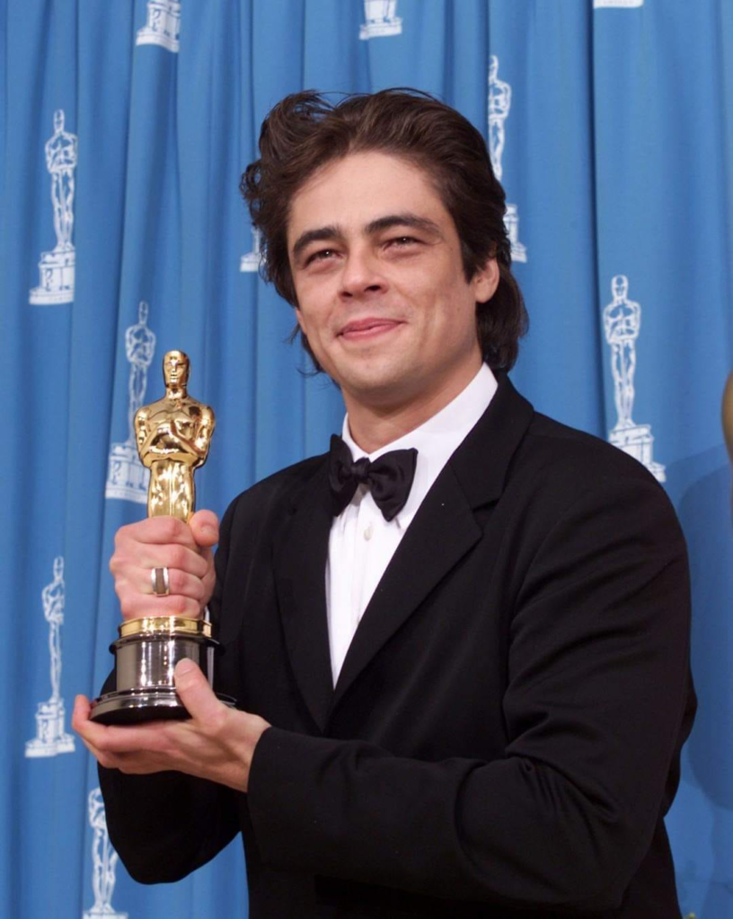 Benicio del Toro holding his Academy Award