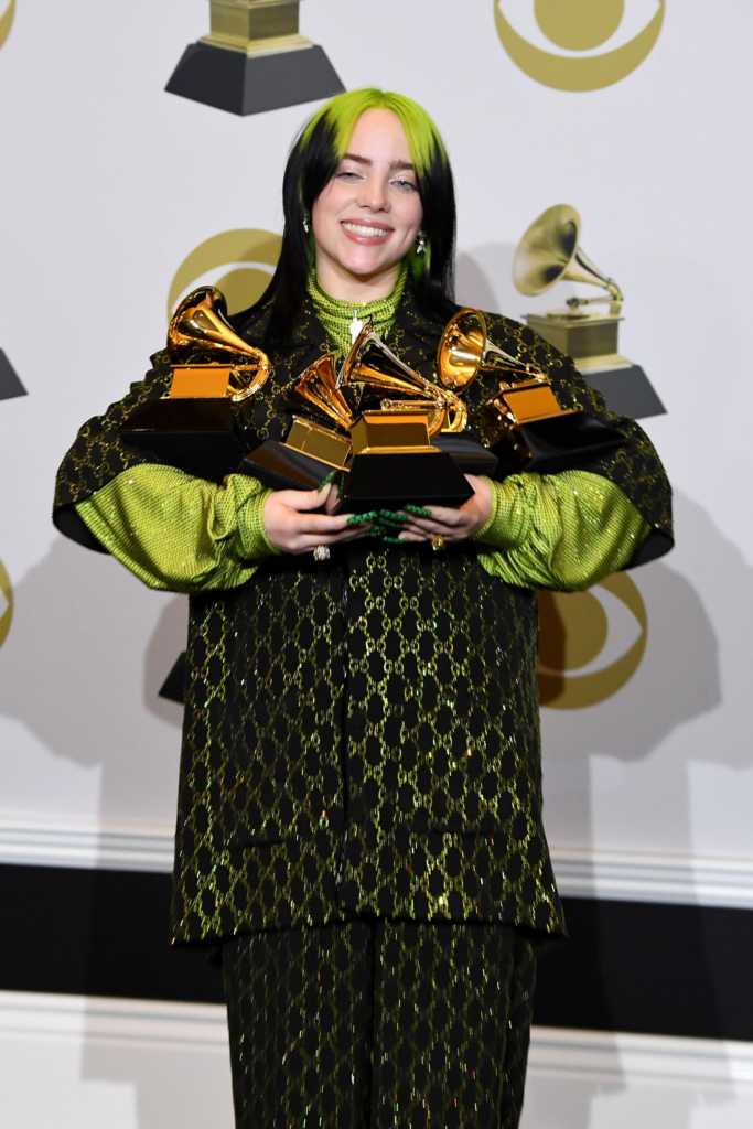 Billie Eilish holding the 4 Grammys she won in a one night