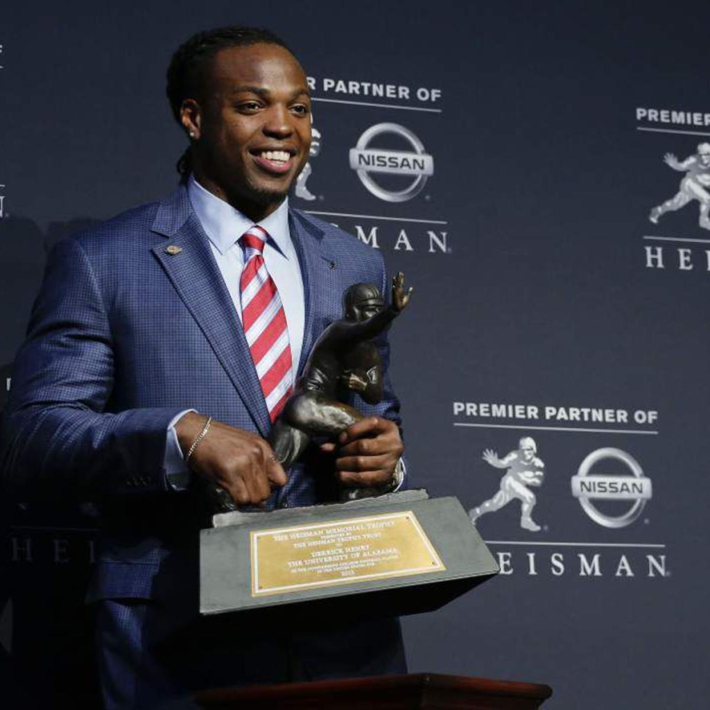 Derrick Henry holding the Heisman Trophy after winning the award in 2015