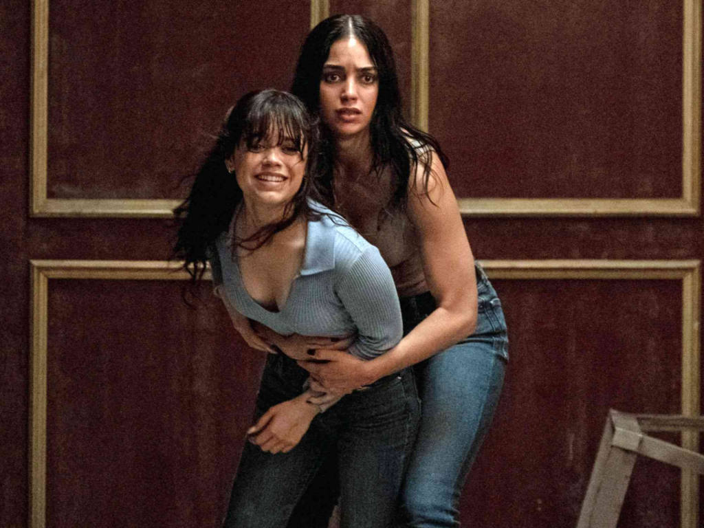 a tense scene from the 2023 horror film Scream VI featuring actors Melissa Barrera and Jenna Ortega