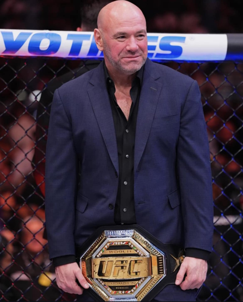 UFC President Dana White holding a UFC championship belt in the octagon
