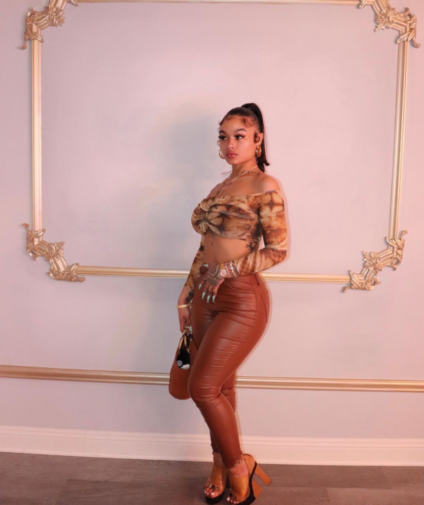 India Love wearing a Fashion Nova tie-dye crop top paired with camel-colored faux leather pants