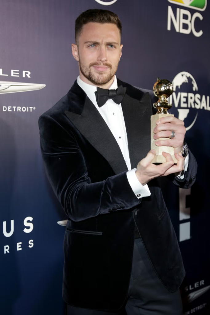 Aaron Taylor-Johnson holding his award for Best Supporting Actor at the 74th Annual Golden Globe Awards in 2017