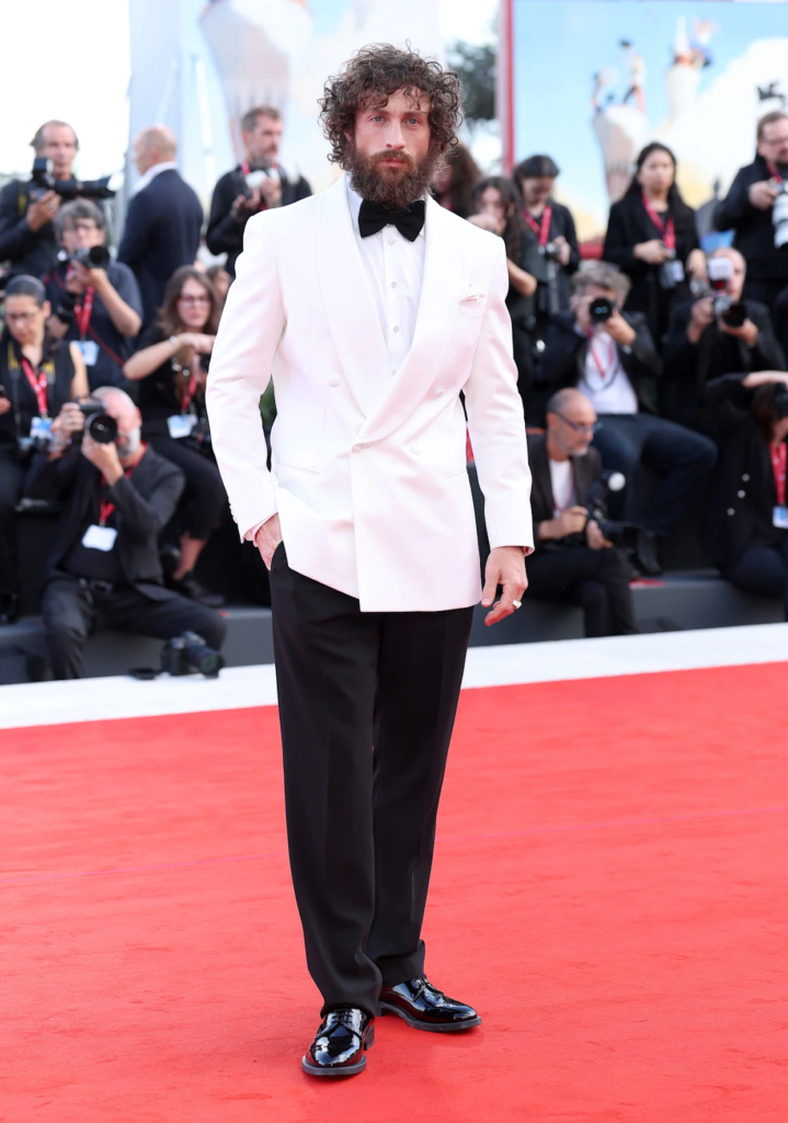 Aaron Taylor-Johnson wearing a custom white Giorgio Armani tuxedo jacket on the red carpet at the 82nd Venice International Film Festival on August 30, 2025