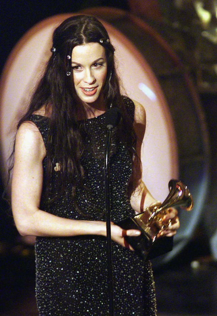 Alanis Morissette holding a Grammy award at the 38th Annual Grammy Awards on February 28, 1996