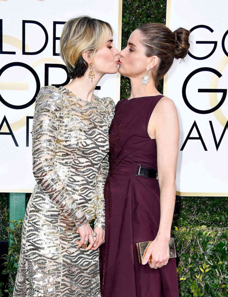 Sarah Paulson and Amanda Peet sharing a kiss on the red carpet at the 74th Annual Golden Globe Awards in January 2017
