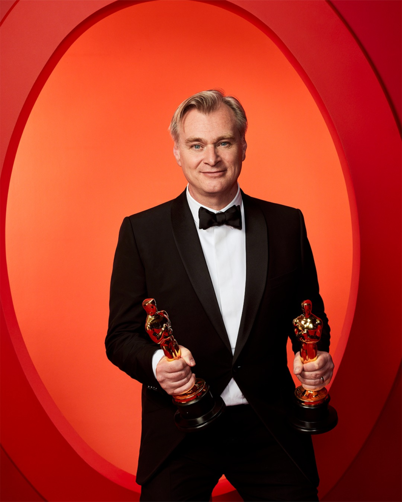 filmmaker Christopher Nolan holding two Academy Awards