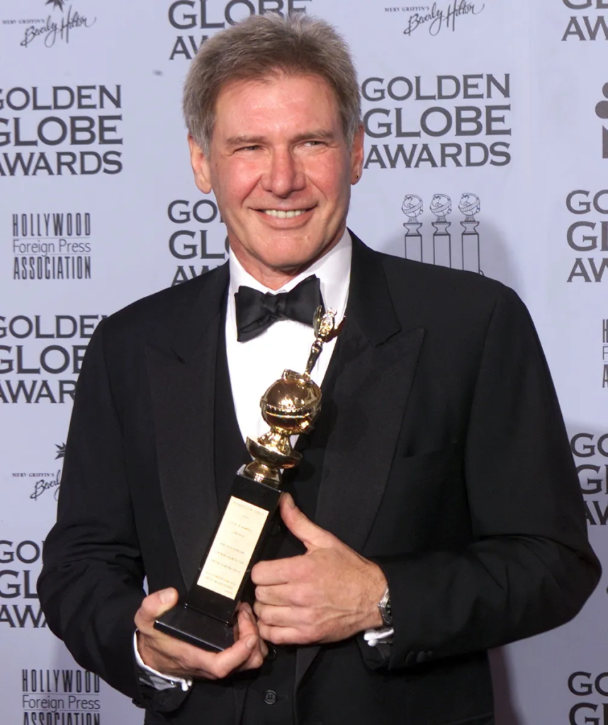 actor Harrison Ford holding the Cecil B. DeMille Award at the 59th Annual Golden Globe Awards in January 2002