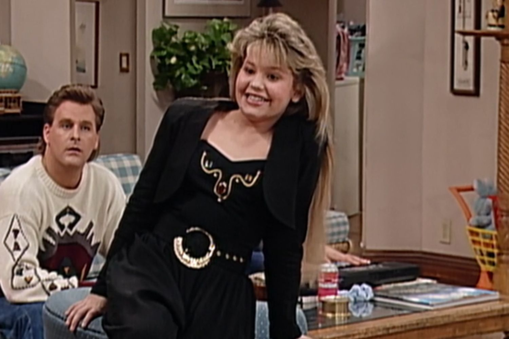 a scene from Full House where Candace Cameron Bure, playing D.J. Tanner, wears an iconic black bolero jacket with MC Hammer pants