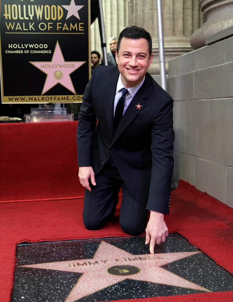 television host Jimmy Kimmel kneeling beside his Hollywood Walk of Fame star during his induction ceremony
