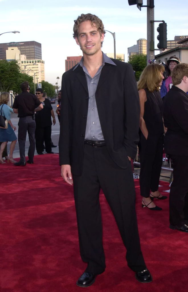Paul Walker attending the premiere of The Fast and the Furious in a black suit with a purple dress shirt