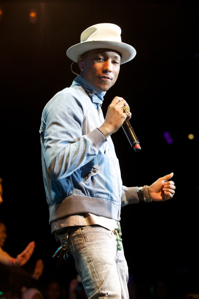 Pharrell Williams performing on stage wearing his iconic, large-brimmed Vivienne Westwood hat
