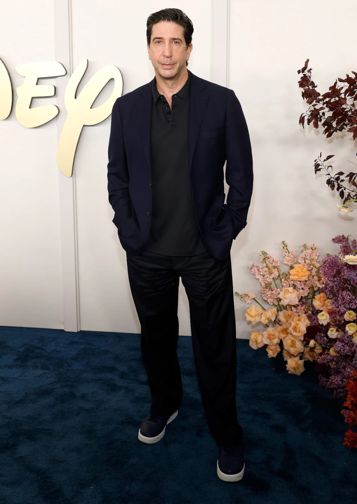 David Schwimmer attends the 2024 Disney Upfront wearing a dark blazer over a matching polo shirt and trousers