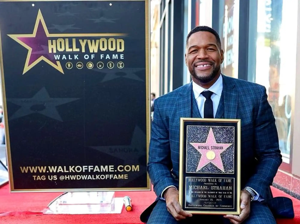Michael Strahan holding his Hollywood Walk of Fame star plaque, awarded in the Sports Entertainment category on January 23, 2023