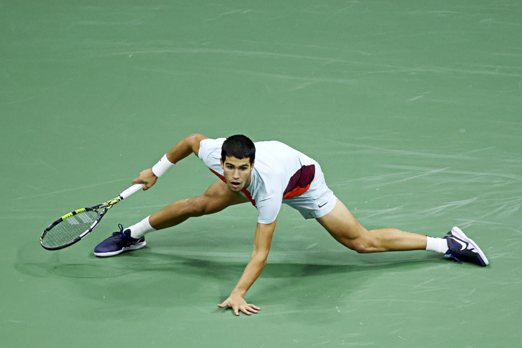 Carlos Alcaraz diving for a shot during a match, a move that highlights his exceptional speed and athleticism