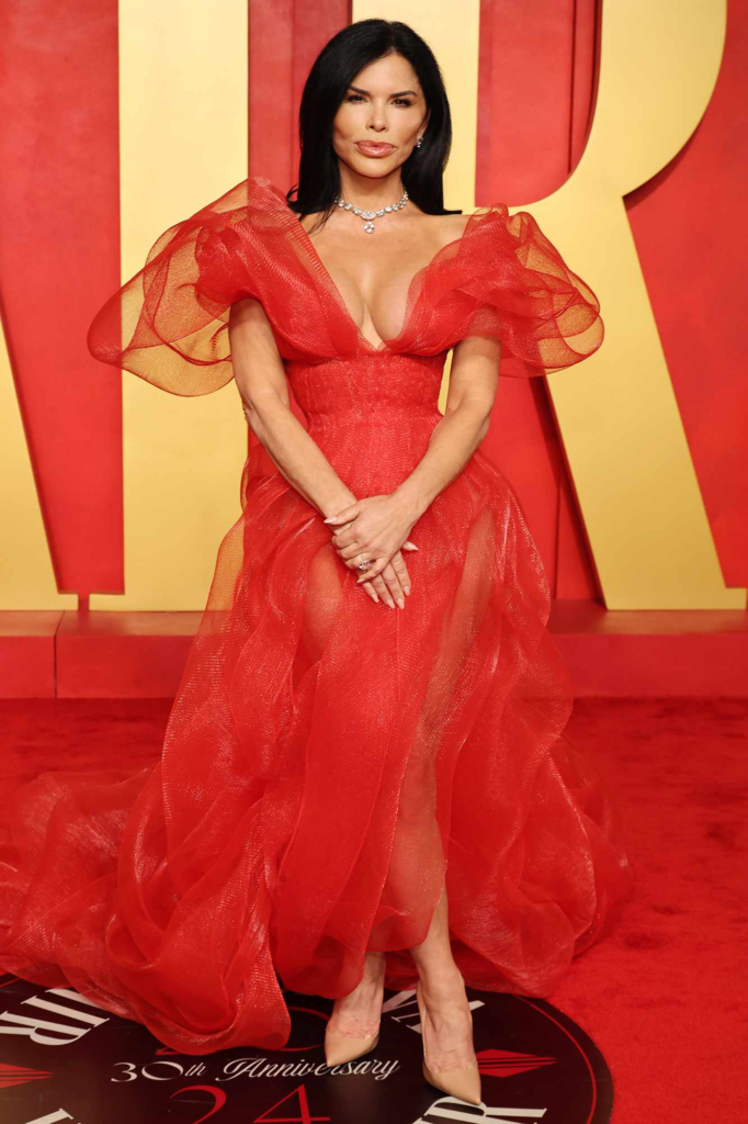 Lauren Sánchez wore a fiery red Lever Couture gown featuring dramatic sheer sleeves to the 2024 Vanity Fair Oscar Party