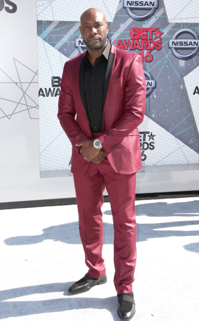 Actor Morris Chestnut is pictured wearing a silk burgundy suit with a black button-down shirt at the 2016 BET Awards