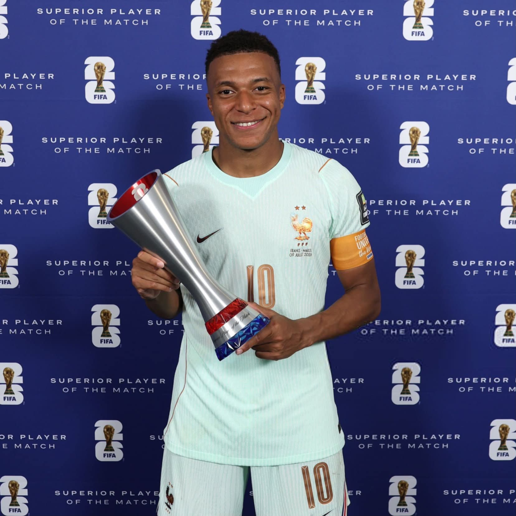 Kylian Mbappé proudly holds the FIFA World Cup Superior Player of the Match trophy wearing the light blue France away jersey after France defeated Morocco 2-0 in the World Cup quarterfinals