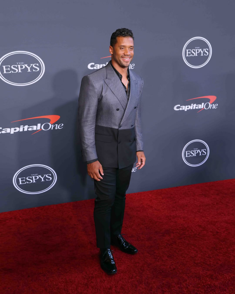 Russell Wilson wore a Dolce & Gabbana Sicilia-fit suit featuring a double-textured black and white design paired with a satin shirt to the 2022 ESPYS