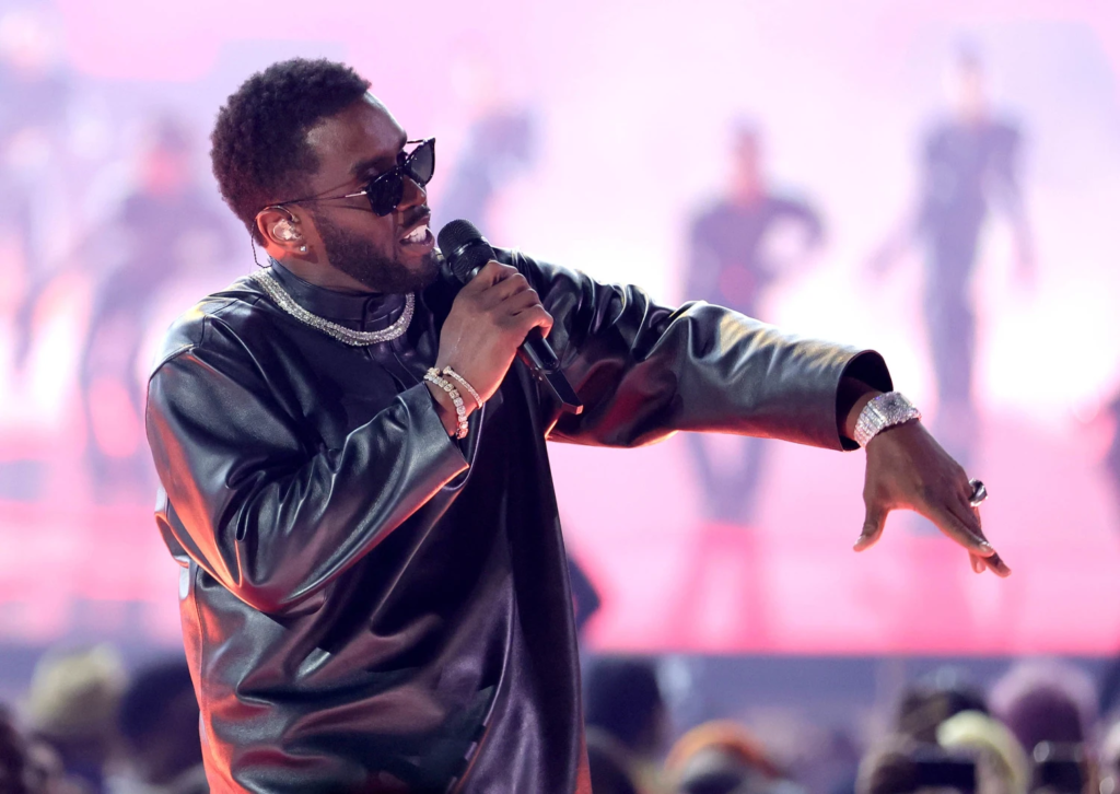 Sean Combs performing on stage at the 2022 Billboard Music Awards while wearing a black leather jacket