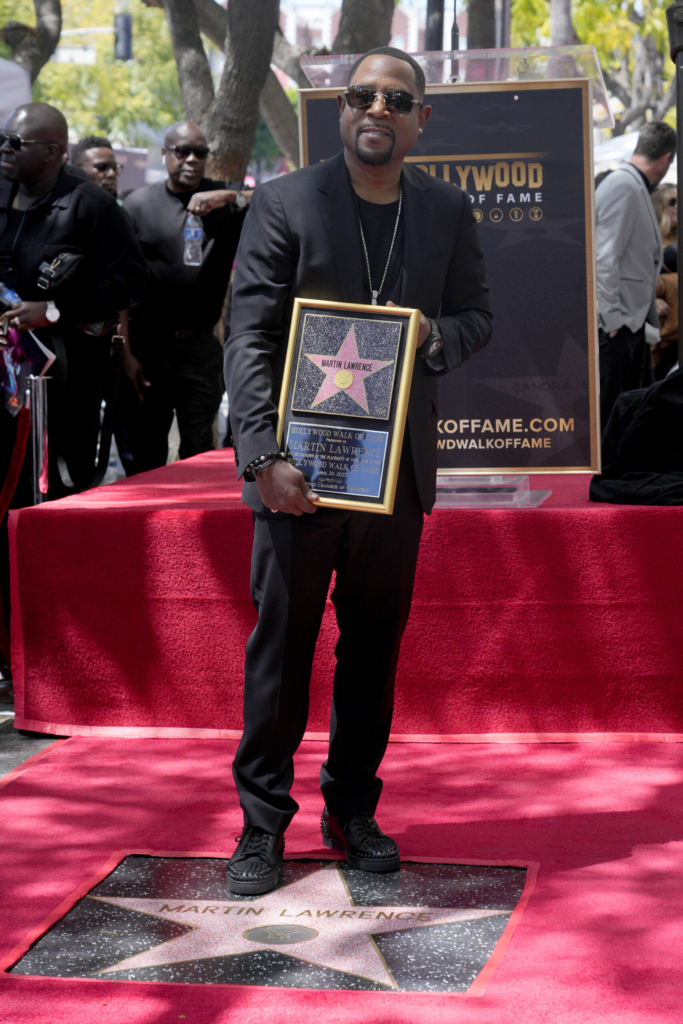 Martin Lawrence holding his award plaque while posing over his newly unveiled star on the Hollywood Walk of Fame