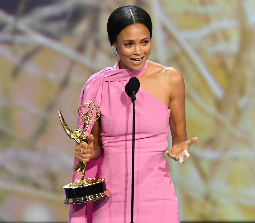 Thandiwe Newton happily poses in a bright pink Brandon Maxwell gown while holding her Emmy award for Supporting Actress in a Drama Series for Westworld