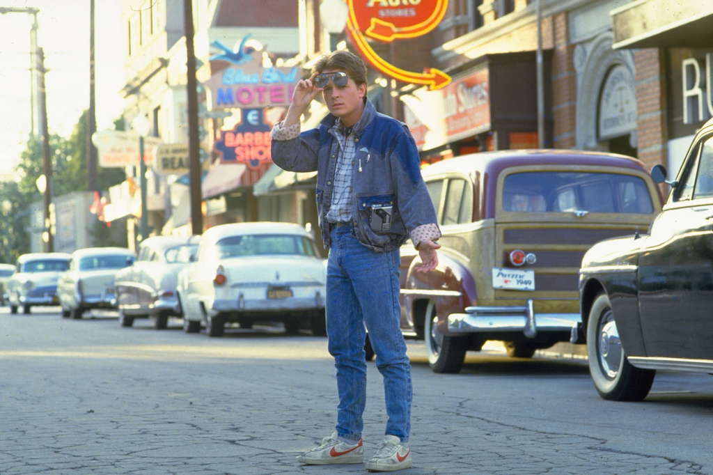 Michael J. Fox as Marty McFly from the 1985 film Back to the Future, wearing his signature Guess denim jacket over a plaid shirt