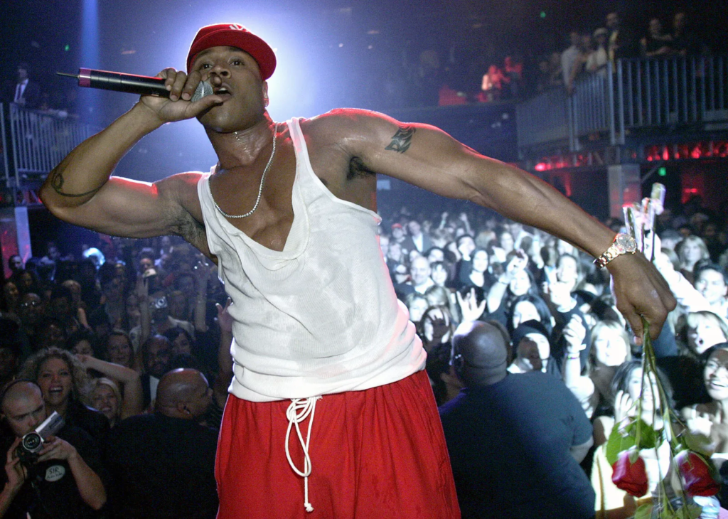 LL Cool J performing in a white tank top and red sweatpants
