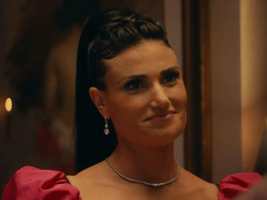 Idina Menzel as Dinah Ratner wearing a vintage pink dress in a dramatic scene from the 2019 crime thriller film Uncut Gems