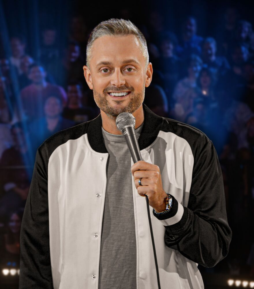 Nate Bargatze performing on stage with a microphone