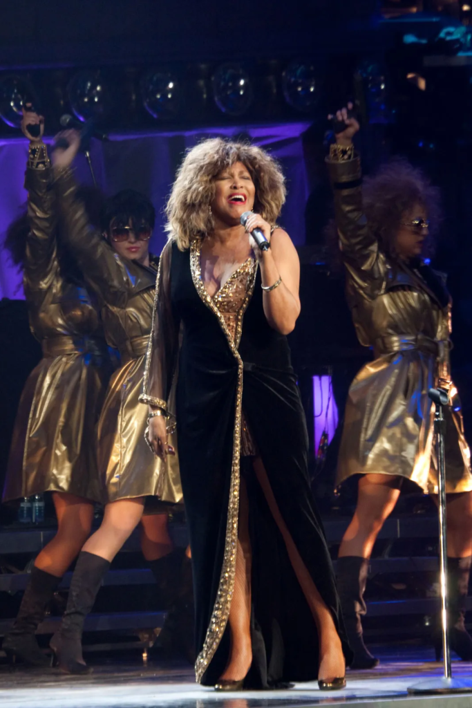 Tina Turner performing on stage with her background dancers