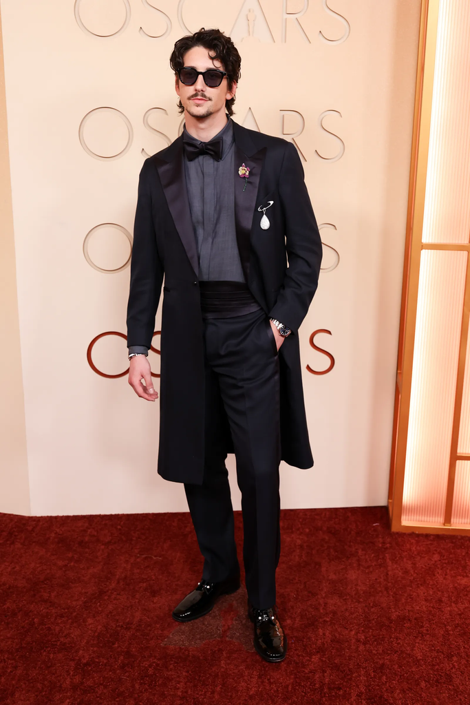 Milo Manheim wore a sharp, custom black coat and suit combination by GapStudio by Zac Posen to the 98th Academy Awards on March 15, 2026