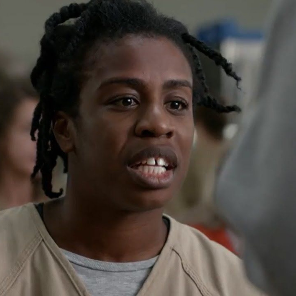 Uzo Aduba portraying the character Suzanne "Crazy Eyes" Warren in the Netflix series Orange Is the New Black, wearing a tan prison uniform