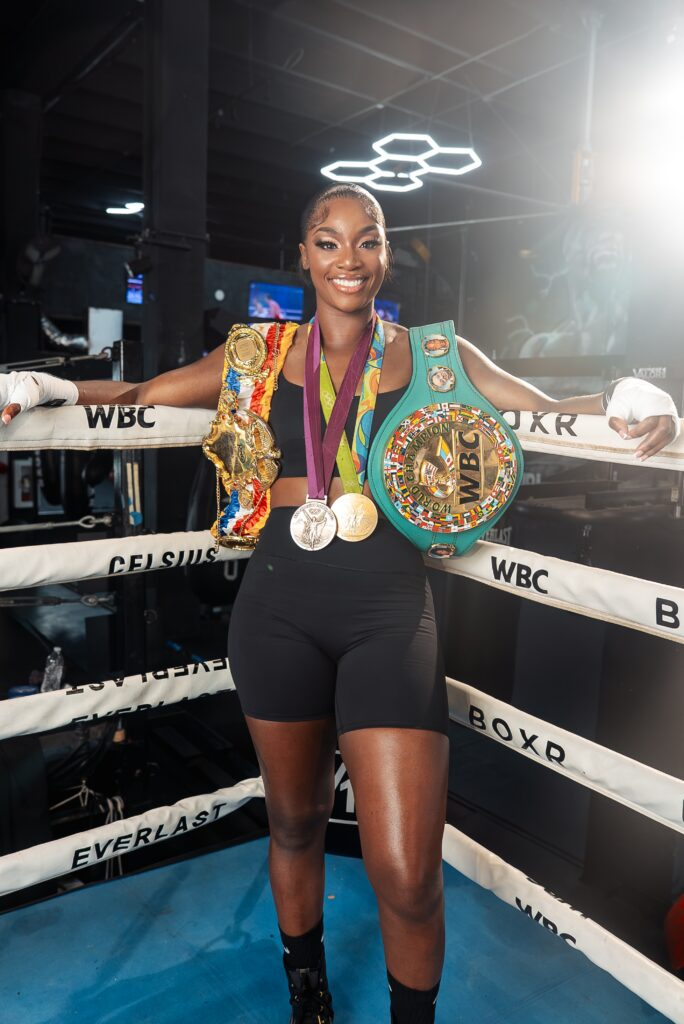 American professional boxer Claressa Shields holding multiple world championship belts