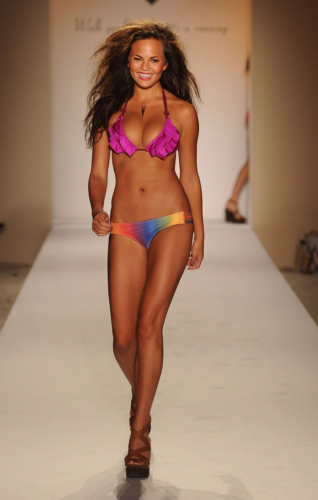 Chrissy Teigen walking the runway during Miami Swim Week in July 2010