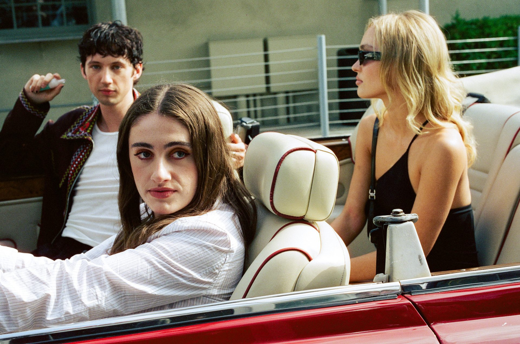 A scene from the HBO drama series The Idol (2023), featuring Rachel Sennott as Leia, Lily-Rose Depp as Jocelyn, and Troye Sivan in the background