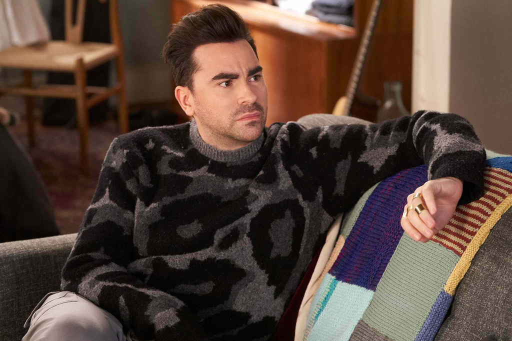 Dan Levy as his character David Rose wearing a black-and-grey animal/leopard print crewneck sweater in the comedy series Schitt's Creek