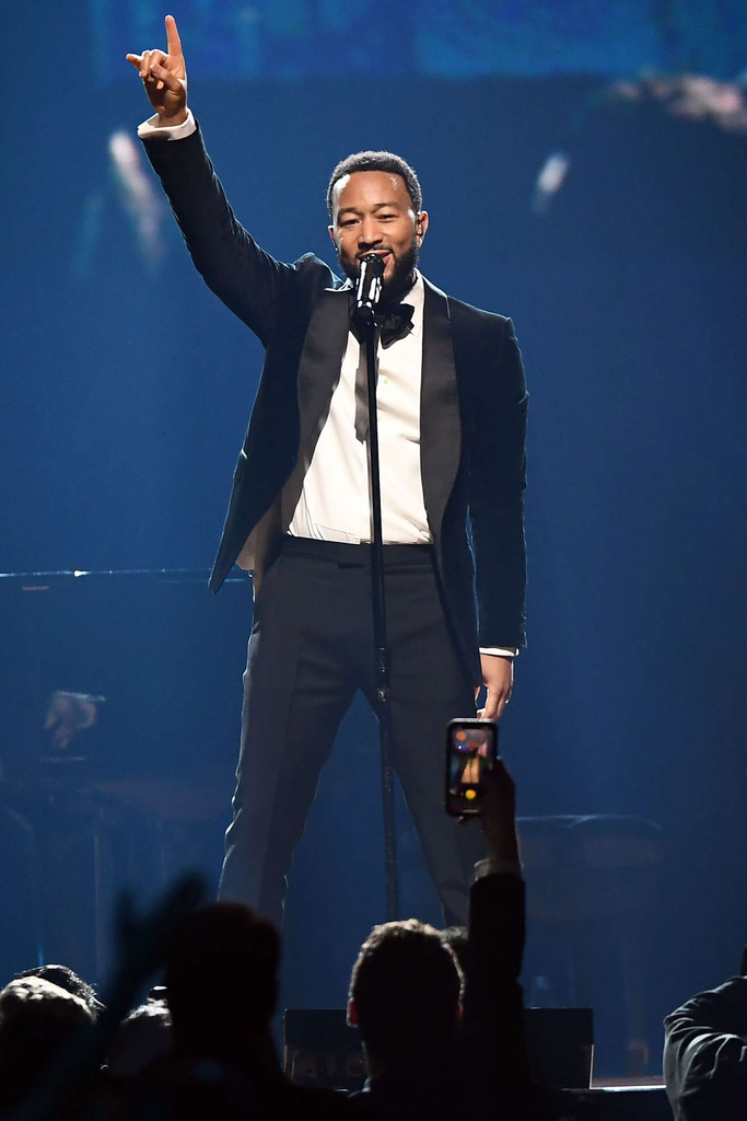 John Legend performs live on stage in a classic black tuxedo during "The Event," a charity fundraiser hosted by the Shaquille O'Neal Foundation in Las Vegas on October 7, 2023